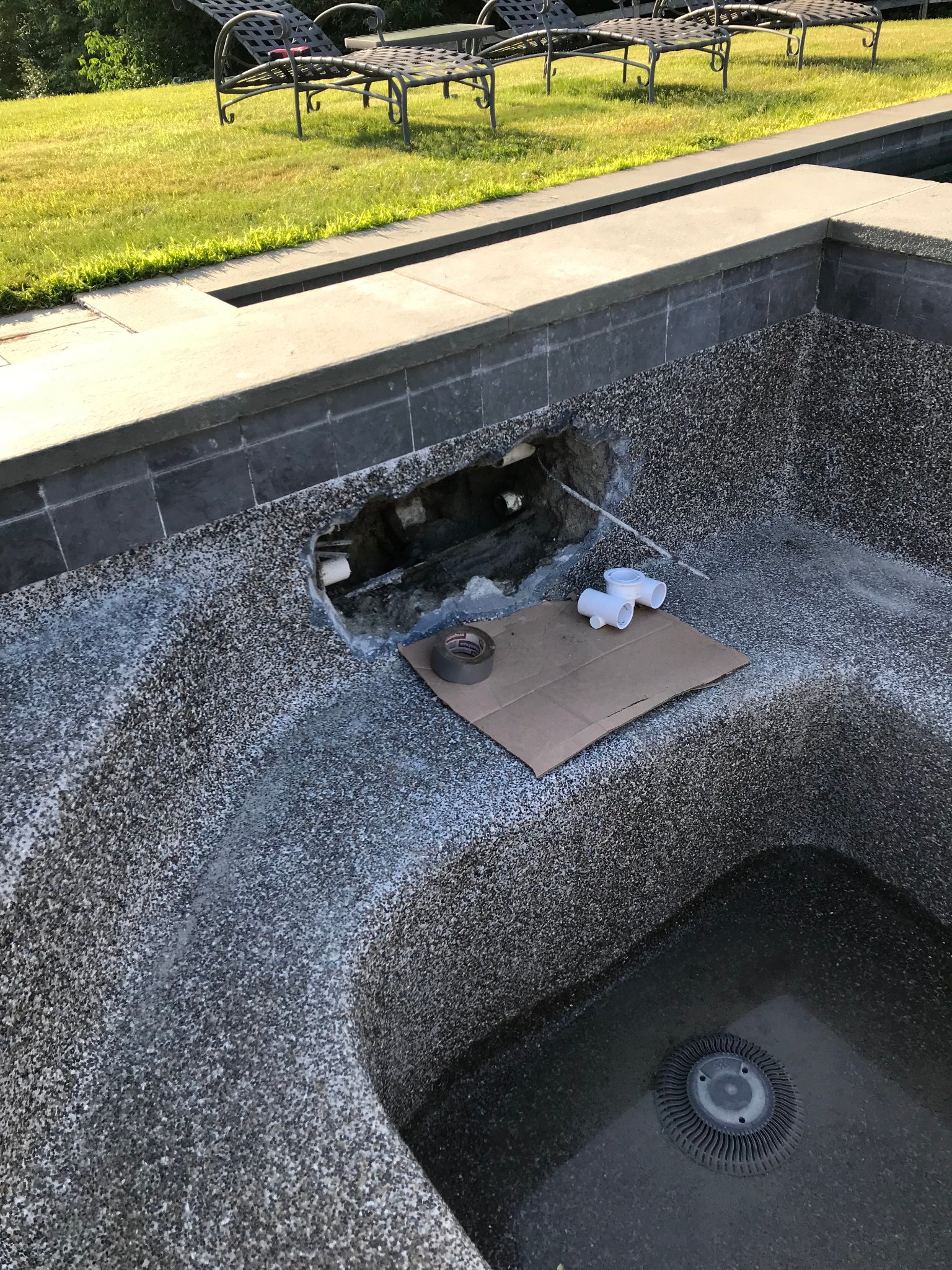 Spa shell opened exposing failed PVC pipe fittings — new fittings staged for installation